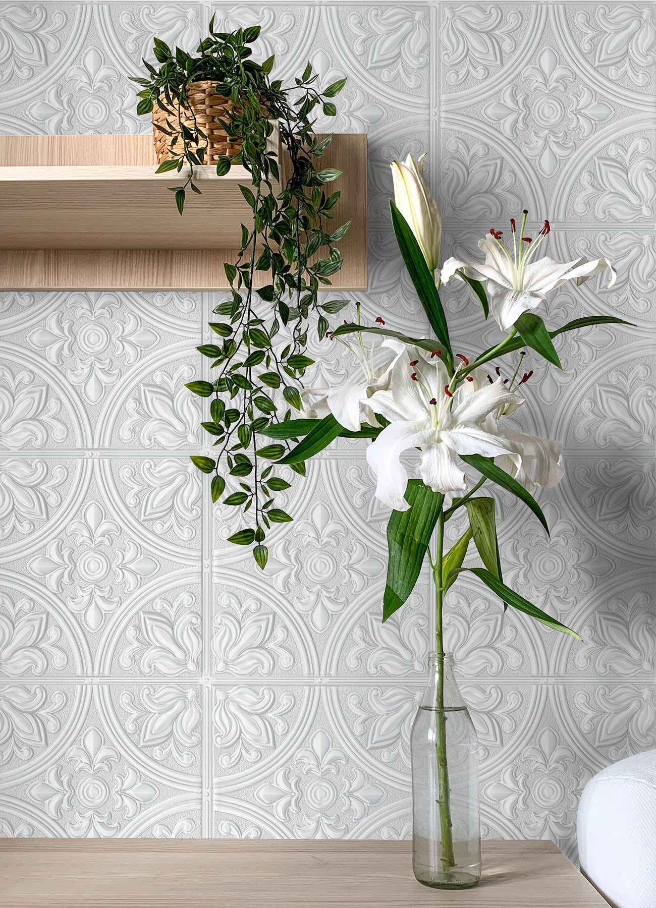 The Ashley Stark Home Willa Tile Peel and Stick Wallpaper by WallPops showcases an ornate, embossed white and light gray tile pattern with symmetrical floral and leaf motifs encircled within each tile. This uniformly repeating design creates a textured, elegant, and vintage look across any surface.