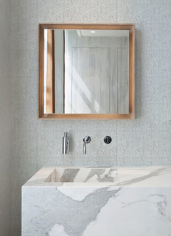 The Ashley Stark Home Willa Tile Peel and Stick Wallpaper by WallPops showcases an ornate, embossed white and light gray tile pattern with symmetrical floral and leaf motifs encircled within each tile. This uniformly repeating design creates a textured, elegant, and vintage look across any surface.