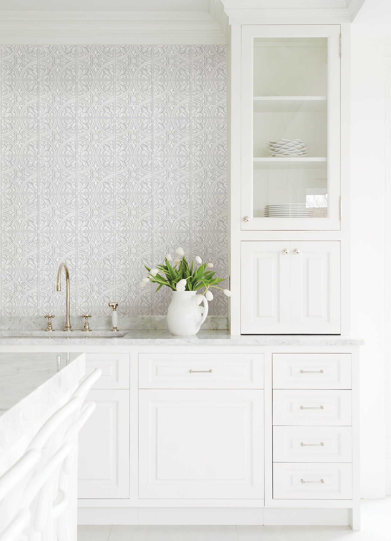 The Ashley Stark Home Willa Tile Peel and Stick Wallpaper by WallPops showcases an ornate, embossed white and light gray tile pattern with symmetrical floral and leaf motifs encircled within each tile. This uniformly repeating design creates a textured, elegant, and vintage look across any surface.