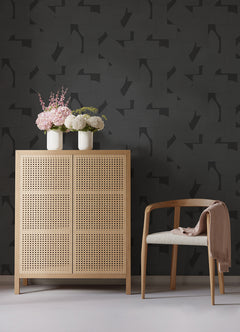 Featuring a pattern of overlapping black geometric shapes—rectangles, semicircles, and squares—set against a dark background, the Ashley Stark Home Bas Geometric Peel and Stick Wallpaper by WallPops creates a subtly textured effect with its nearly indistinguishable monochromatic design.