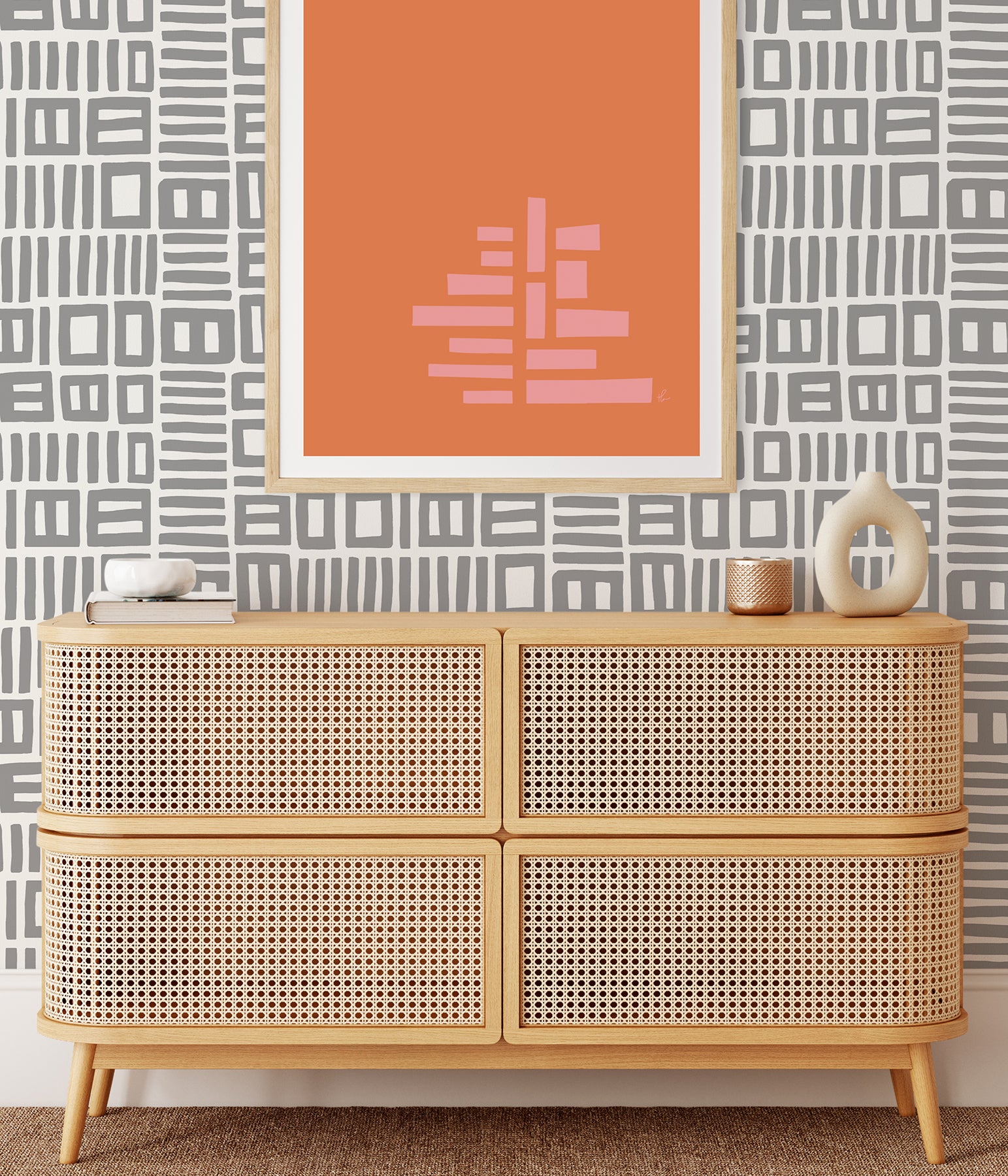 Beneath dark gray cabinets, a backsplash is enhanced with WallPops Black Pepper Paperie Traverse Peel and Stick Wallpaper, showcasing a bold geometric gray and white square pattern reminiscent of striking wallpaper. On the white countertop sit three white canisters with wooden lids alongside a large white bowl filled with green apples.