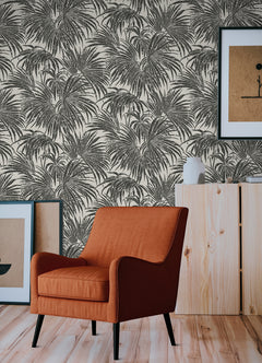 A dense, black and white grunge-style illustration of overlapping cassava palm leaves fills the image, with a light background and distressed textures that give a vintage, weathered appearance—evoking the timeless look of WallPops’ Egypt Sherrod Cassava Palm Peel and Stick Wallpaper. No blank spaces are visible in the pattern.