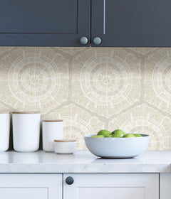 A modern dining room featuring a wooden table, eight black chairs, white built-in cabinets, and blue LiLi WhittWhitt Harmony Peel and Stick Wallpaper by WallPops. Above a white fireplace hangs a colorful abstract portrait. The space is accented with decorative pottery, candles, and a single-stem vase.