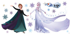 WallPops Frozen 2 Anna, Elsa, and Olaf Purple Wall Decals feature Anna in a black cape and green dress beside Olaf the snowman and Elsa with her shimmering gown among purple and blue snowflakes, a bird, and rustic accents on a white background.