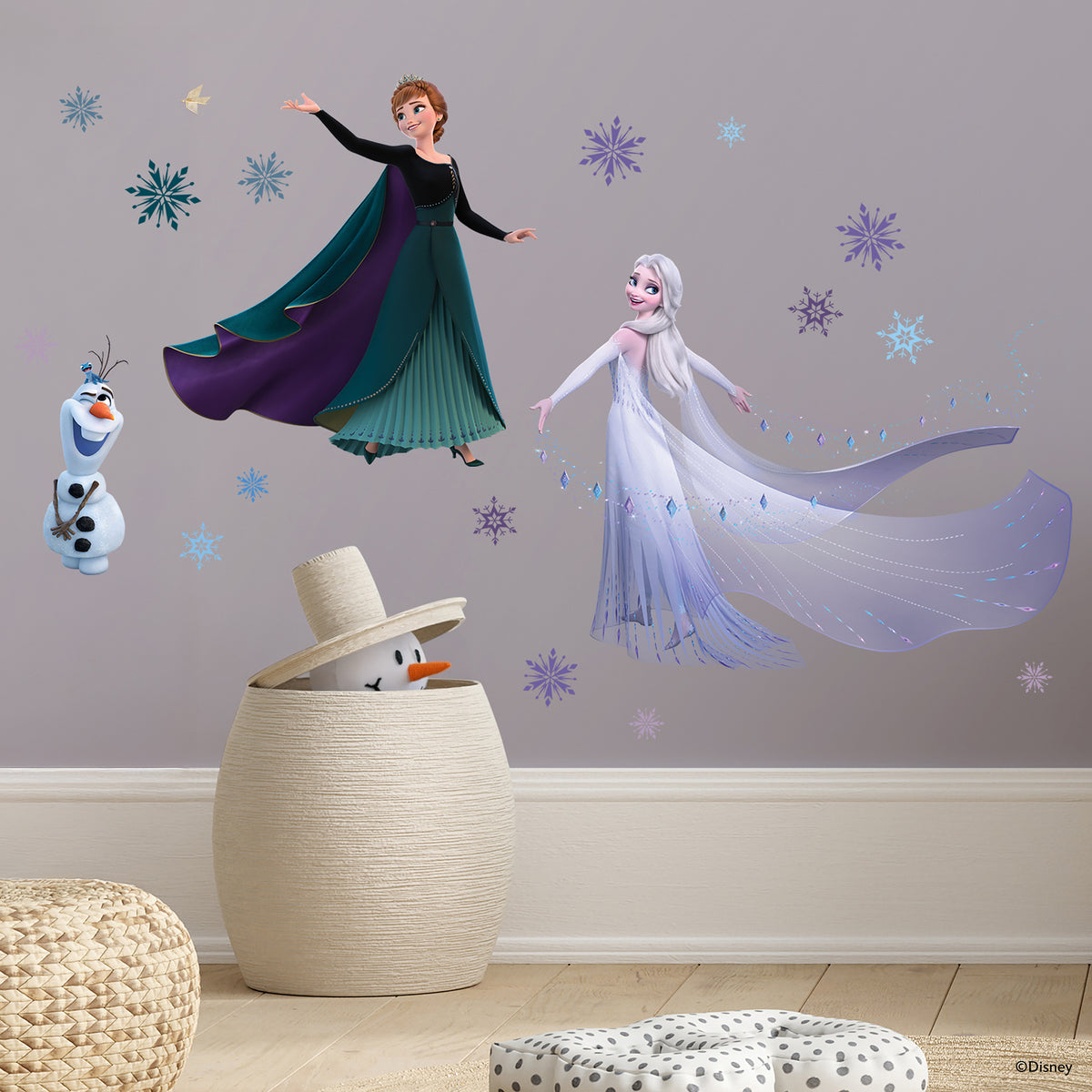 WallPops Frozen 2 Anna, Elsa, and Olaf Purple Wall Decals feature Anna in a black cape and green dress beside Olaf the snowman and Elsa with her shimmering gown among purple and blue snowflakes, a bird, and rustic accents on a white background.