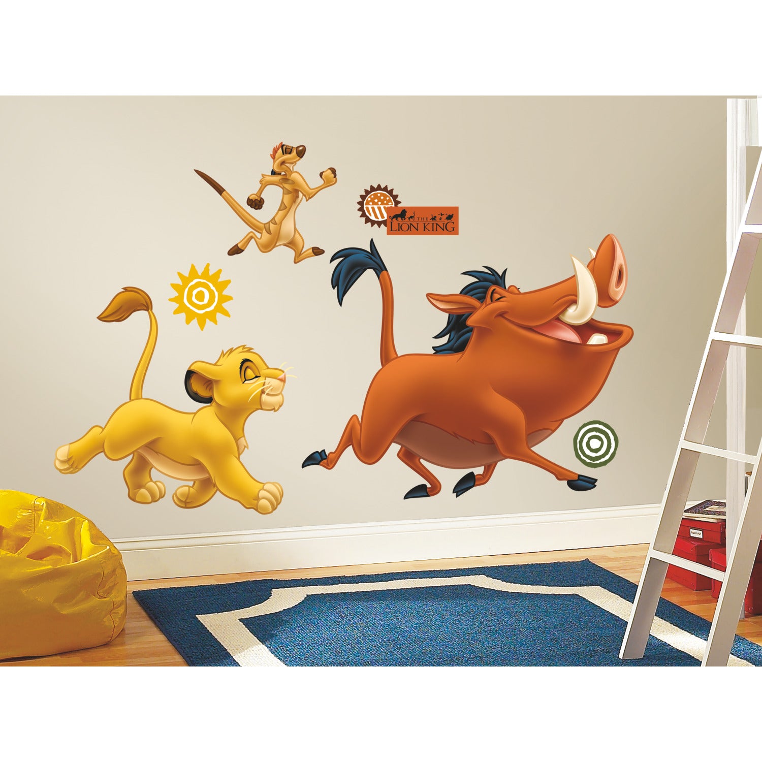 WallPops Disney The Lion King Giant Wall Decals featuring Simba, Timon, and Pumbaa are displayed on a beige wall above a blue rug. A yellow beanbag rests on a wooden floor with a distressed barn wood texture, enhancing the rustic charm of the room, while part of a white ladder appears in the foreground.