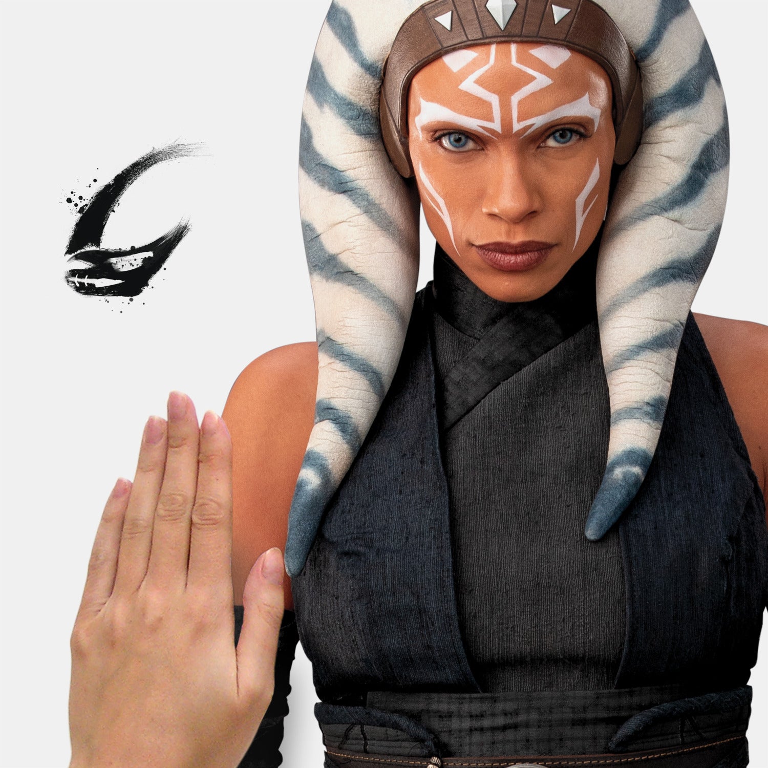 A striking silhouette of Ahsoka Tano, clad in black armor with blue and white striped head-tails and facial markings, stands confidently holding two crossed white lightsabers—her arms wrapped in dark gauntlets—against a plain white background. The Star Wars Ahsoka Peel and Stick Giant Wall Decal by WallPops is an inspiring way to add bold character to any room.