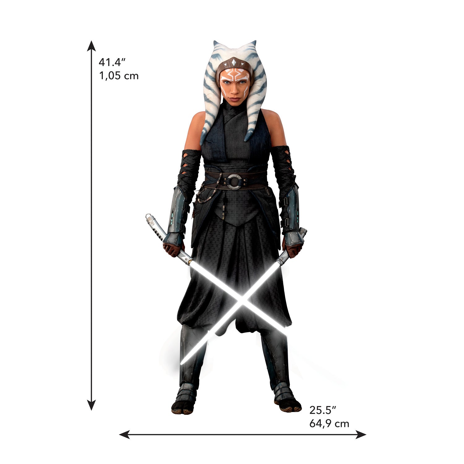 A striking silhouette of Ahsoka Tano, clad in black armor with blue and white striped head-tails and facial markings, stands confidently holding two crossed white lightsabers—her arms wrapped in dark gauntlets—against a plain white background. The Star Wars Ahsoka Peel and Stick Giant Wall Decal by WallPops is an inspiring way to add bold character to any room.