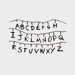 The WallPops Netflix Stranger Things Christmas Lights Peel And Stick Giant Wall Decals With Alphabet features a hand-drawn alphabet arranged in three rows, each row displayed beneath a line of colorful Christmas lights and accented with circled numbers 1–8 along the lines. This rustic design, measuring 27.43 69.6 cm tall by 46.04 1.16 m wide, boasts a light gray background reminiscent of distressed barn wood for added character.