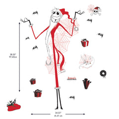 Giant Disney Tim Burtons The Nightmare Before Christmas Holiday Wall Decals by WallPops, featuring Jack Skellington, Zero, bats, spider webs, skulls, and presents, decorate the living room wall above a couch adorned with tree pillows. Rustic barn wood accents enhance the festive scene, while wrapped gifts, a lantern, and a blanket on the floor create a cozy blend of Halloween and Christmas décor.