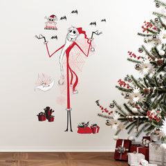 Giant Disney Tim Burtons The Nightmare Before Christmas Holiday Wall Decals by WallPops, featuring Jack Skellington, Zero, bats, spider webs, skulls, and presents, decorate the living room wall above a couch adorned with tree pillows. Rustic barn wood accents enhance the festive scene, while wrapped gifts, a lantern, and a blanket on the floor create a cozy blend of Halloween and Christmas décor.