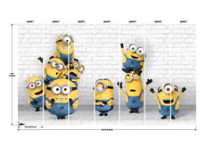Eight Minions in blue overalls, with their signature yellow bodies and goggles, stand and stack joyfully against a white brick wall in the WallPops Minions Making Mischief Peel and Stick Mural. Some raise their arms in excitement, one perches playfully on top of another, and all display cheerful expressions.