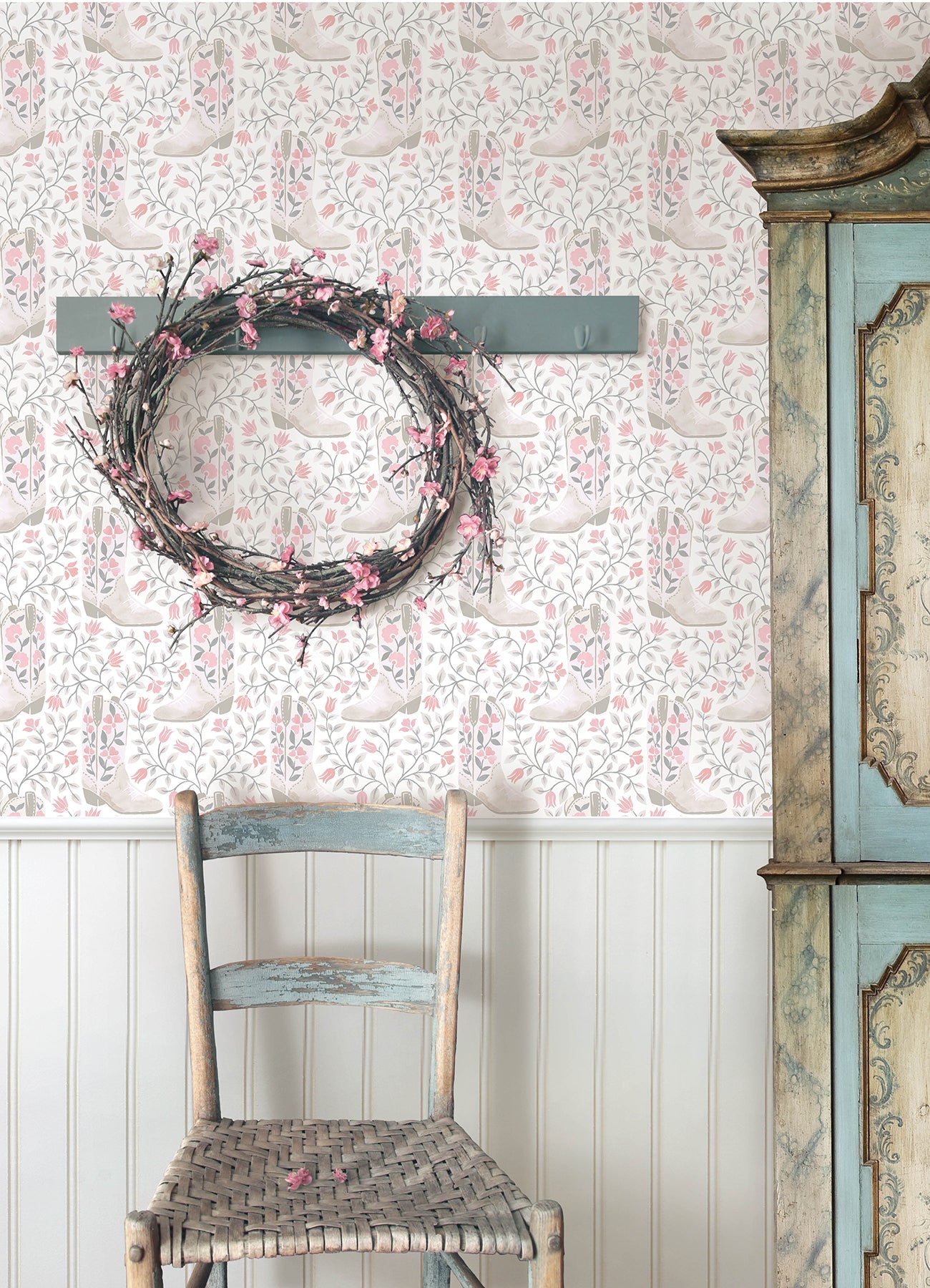 Introducing the Cowgirl Like Me Peel and Stick Wallpaper by WallPops—this seamless wallpaper showcases pale beige cowboy boots accented with delicate floral motifs, all arranged against a light backdrop interwoven with winding leafy vines and dainty blossoms. The soft, muted illustration style lends a subtle vintage charm, making it the ideal choice for anyone seeking adorable cowgirl-inspired décor.
