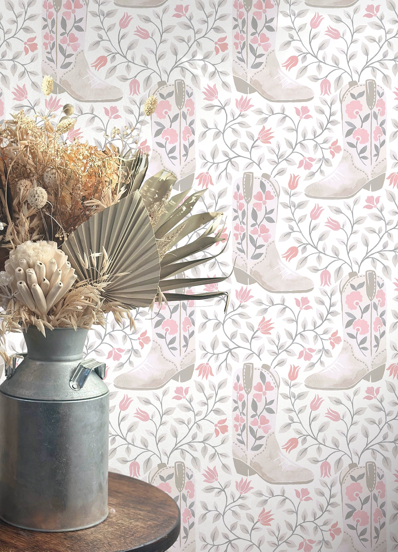 Introducing the Cowgirl Like Me Peel and Stick Wallpaper by WallPops—this seamless wallpaper showcases pale beige cowboy boots accented with delicate floral motifs, all arranged against a light backdrop interwoven with winding leafy vines and dainty blossoms. The soft, muted illustration style lends a subtle vintage charm, making it the ideal choice for anyone seeking adorable cowgirl-inspired décor.