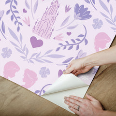WallPops Frozen II Frozen Castle Damask Peel and Stick Wallpaper features pastel pink and lavender castle motifs with floral patterns, stylized flowers, leaves, hearts, and face profiles. Removable. Dimensions: 18 ft x 20.5 in.
