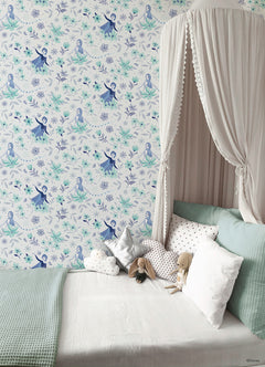 Hands with a silver ring smooth Frozen II Frozen 2 Anna and Elsa Floral Peel and Stick Wallpaper by WallPops onto a cream wall, aligning its repeating pink floral pattern and cartoon girls in blue dresses.