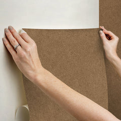 A close-up view of a cork board surface reveals a natural, subtly uneven texture composed of tiny light to medium brown granules pressed together. This organic look would beautifully complement WallPops’ RuPaul RuSuede Peel and Stick Wallpaper or pair seamlessly with other azure blue wallcoverings for easy and stylish customization. The surface is shown free from any objects, pins, or text.