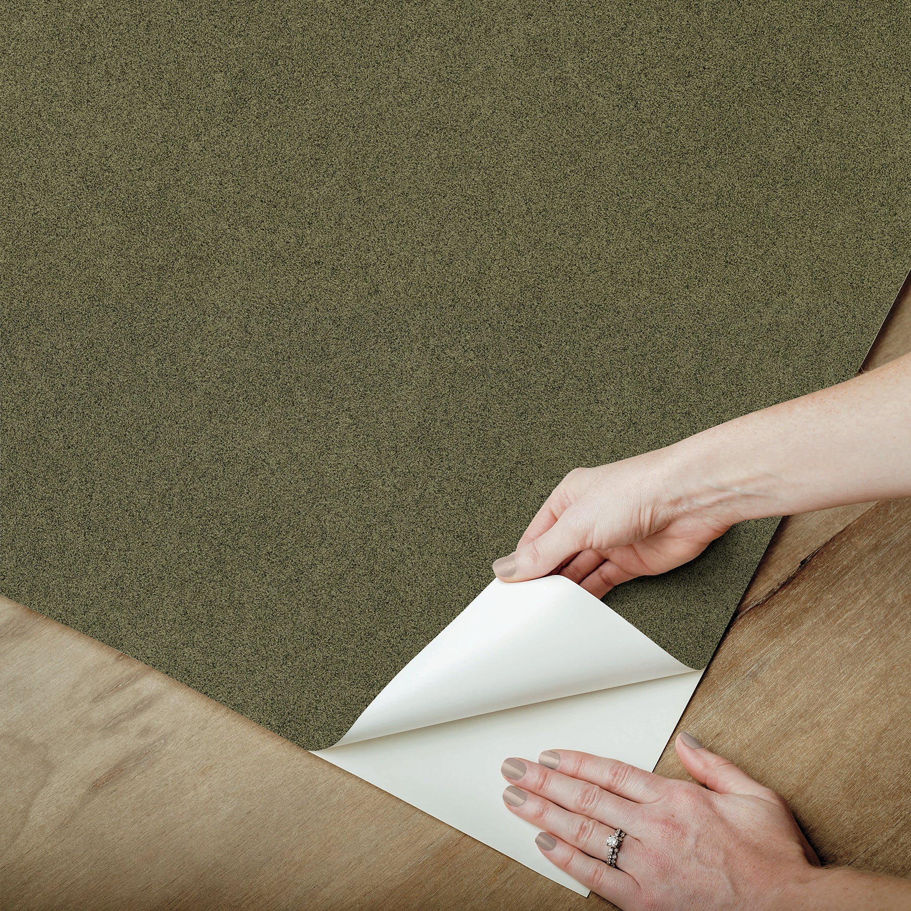 A close-up view of a cork board surface reveals a natural, subtly uneven texture composed of tiny light to medium brown granules pressed together. This organic look would beautifully complement WallPops’ RuPaul RuSuede Peel and Stick Wallpaper or pair seamlessly with other azure blue wallcoverings for easy and stylish customization. The surface is shown free from any objects, pins, or text.