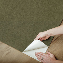 A close-up view of a cork board surface reveals a natural, subtly uneven texture composed of tiny light to medium brown granules pressed together. This organic look would beautifully complement WallPops’ RuPaul RuSuede Peel and Stick Wallpaper or pair seamlessly with other azure blue wallcoverings for easy and stylish customization. The surface is shown free from any objects, pins, or text.