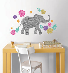Bring vibrant artistry to your space with the WallPops Mehndi Small Wall Art Kits. This kit features a highly detailed black and white elephant illustration adorned with ornate designs, standing right amidst an array of intricate, colorful flowers in pink, yellow, orange, purple, and teal hues, complemented by lush green leaves on a crisp white background.